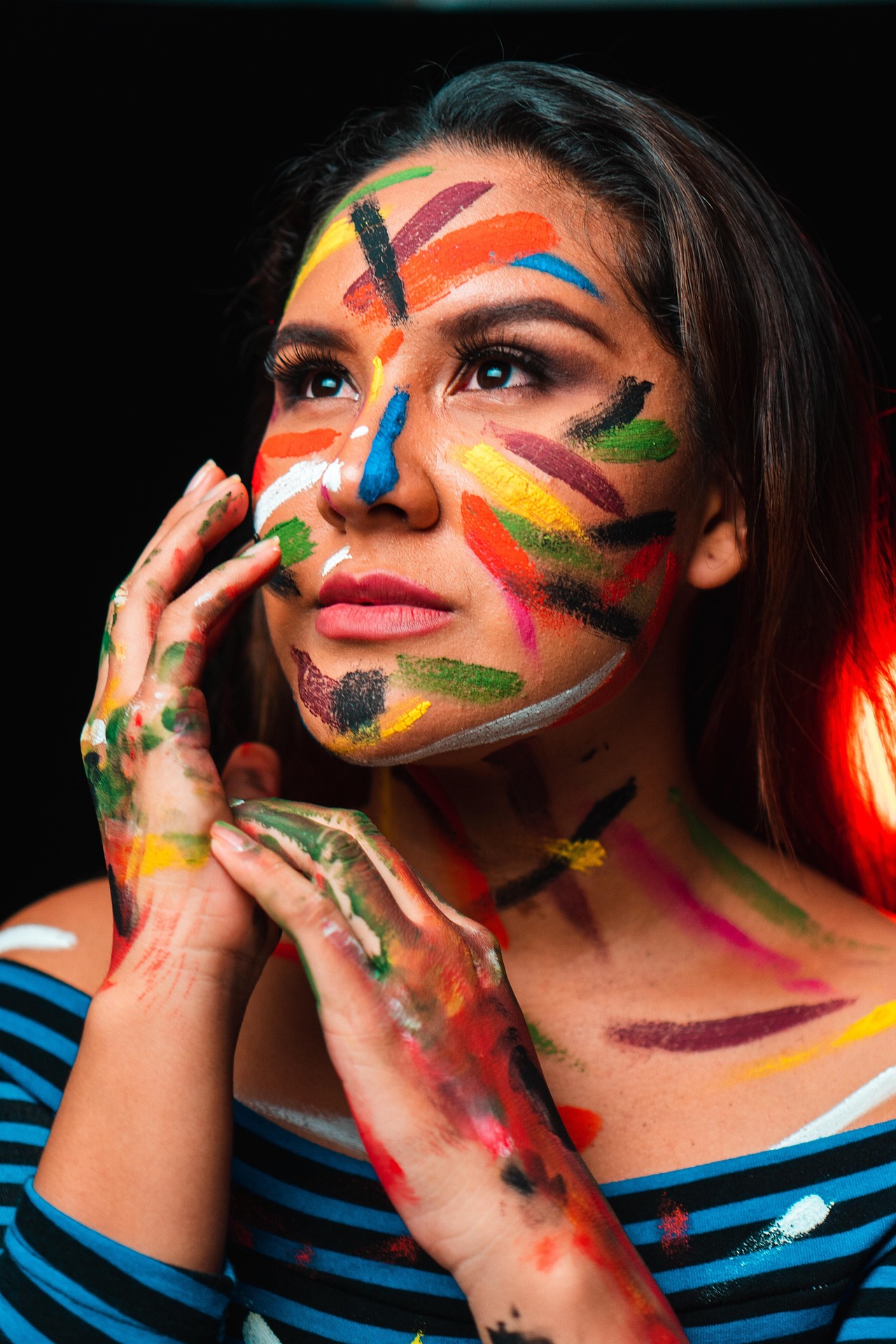 Woman with colourful paint on her face symbolising creative renewal